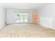 Bright living room with fireplace, neutral carpet, white fireplace mantel, and French doors to the backyard at 475 Golf Ln, Indianapolis, IN 46260