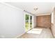 Carpeted sunroom with sliding glass doors to backyard and brick wall at 475 Golf Ln, Indianapolis, IN 46260