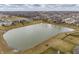 Aerial view of a community with a pond in the foreground and many single Gathering homes at 5442 W Turnbuckle Pl, McCordsville, IN 46055