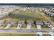 Community aerial view with houses surrounding a pond at 5442 W Turnbuckle Pl, McCordsville, IN 46055