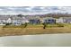 View of dark blue home backyard and the surrounding houses on the opposite side of the pond at 5442 W Turnbuckle Pl, McCordsville, IN 46055