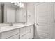 Bathroom featuring double sinks with white cabinets, quartz countertop, a large mirror, and modern lighting at 5442 W Turnbuckle Pl, McCordsville, IN 46055