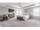 Spacious bedroom with plush carpet, a sitting area, a ceiling fan, and large windows providing lots of natural light at 5442 W Turnbuckle Pl, McCordsville, IN 46055