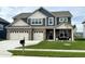 Charming two-story home featuring a manicured lawn, brick accents, and a welcoming front porch at 5442 W Turnbuckle Pl, McCordsville, IN 46055