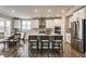 Open-concept kitchen boasts stainless steel appliances, island seating, and stylish pendant lighting at 5442 W Turnbuckle Pl, McCordsville, IN 46055