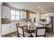 Eat-in kitchen featuring a round table with upholstered chairs and view of large kitchen island at 5442 W Turnbuckle Pl, McCordsville, IN 46055