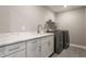 Well-organized laundry room with modern washer and dryer, ample counter space, and sleek cabinets at 5442 W Turnbuckle Pl, McCordsville, IN 46055