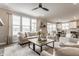 Bright, open living room with large windows, hardwood floors, and neutral-toned furniture at 5442 W Turnbuckle Pl, McCordsville, IN 46055