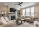 Cozy living room featuring a fireplace, comfortable seating, and a modern ceiling fan at 5442 W Turnbuckle Pl, McCordsville, IN 46055
