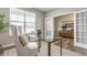 Bright office space with a glass desk, comfortable chair, and natural light from a large window at 5442 W Turnbuckle Pl, McCordsville, IN 46055