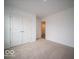 Cozy bedroom with neutral carpet, white walls, and a closet for storage at 6618 Sulgrove Pl, Indianapolis, IN 46221