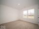 Bright bedroom with neutral carpet, white walls, and a large window offering natural light at 6618 Sulgrove Pl, Indianapolis, IN 46221