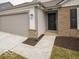 Close-up of the home's entrance with a two-car garage, stone accents, and walkway at 6618 Sulgrove Pl, Indianapolis, IN 46221