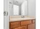 Bathroom with a single sink vanity with wood cabinets and a large mirror at 7218 Forrester Ln, Indianapolis, IN 46217