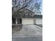 Tan two-story townhome with attached two-car garage and landscaping at 7218 Forrester Ln, Indianapolis, IN 46217