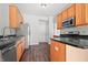A kitchen with stainless steel appliances, wood cabinets, and a dark countertop at 7218 Forrester Ln, Indianapolis, IN 46217
