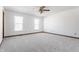 Spacious bedroom with neutral carpet, a ceiling fan, and abundant natural light from two windows at 7669 Camberwood Dr, Indianapolis, IN 46268