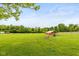Expansive backyard with a shed and fire pit, surrounded by mature trees and lush greenery at 7775 N Kitchen Rd, Mooresville, IN 46158