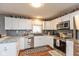 Well-lit kitchen featuring white cabinets, stainless steel appliances, and a mosaic tile backsplash at 7775 N Kitchen Rd, Mooresville, IN 46158