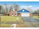 Charming brick home with a blue accent, attached garage, and driveway at 7817 Dartmouth Rd, Indianapolis, IN 46260