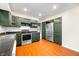 Kitchen with dark green cabinets, stainless steel appliances and hardwood floors at 7817 Dartmouth Rd, Indianapolis, IN 46260