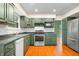 Kitchen with dark green cabinets, stainless steel appliances and hardwood floors at 7817 Dartmouth Rd, Indianapolis, IN 46260