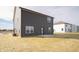 Home backyard view featuring dark siding, neutral lawn, and a concrete patio at 7872 Magnolia St, New Palestine, IN 46163