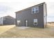 Exterior elevation showcases the home's dark siding, trimmed windows, and patio at 7872 Magnolia St, New Palestine, IN 46163