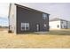 Exterior elevation showcases the home's dark siding, trimmed windows, and patio at 7872 Magnolia St, New Palestine, IN 46163