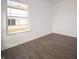 Minimalist bedroom with white walls, dark wood floors, a large window with outside view, and ample natural light at 7872 Magnolia St, New Palestine, IN 46163