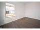 Bedroom featuring clean white walls, dark wood-look flooring, and ample natural light from a window at 7872 Magnolia St, New Palestine, IN 46163