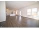 Open-concept living space with white walls, dark wood floors, and views into the modern kitchen with stainless steel appliances at 7872 Magnolia St, New Palestine, IN 46163