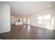 Open-concept living room with white walls and dark floors flowing into the kitchen and dining area at 7872 Magnolia St, New Palestine, IN 46163