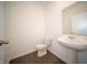 Powder room features a pedestal sink, modern toilet, and dark wood-look floors at 7872 Magnolia St, New Palestine, IN 46163