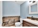 Updated half bathroom with wood-look tile and modern vanity at 9210 Briarclift Rd, Indianapolis, IN 46256