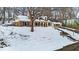 Brick home on a snow covered lot with mature trees and retaining wall at 9210 Briarclift Rd, Indianapolis, IN 46256