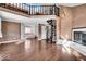 Spacious living room featuring a fireplace, spiral staircase, and hardwood floors at 9210 Briarclift Rd, Indianapolis, IN 46256