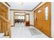 Bright entryway with tile floors, wooden staircase, and view of dining room at 9667 Spruance Ct, Indianapolis, IN 46256