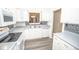 White kitchen with gray countertops, mosaic backsplash, and stainless steel sink at 10832 Harness Way, Indianapolis, IN 46239