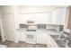 White kitchen boasts modern appliances and gray countertops at 10832 Harness Way, Indianapolis, IN 46239
