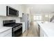 This open-concept kitchen features stainless steel appliances, a center island, and a view of the living area at 10948 Hanovarian St, Zionsville, IN 46077