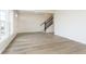 Open-concept living room with wood floors and a staircase, filled with natural light from large windows at 10948 Hanovarian St, Zionsville, IN 46077