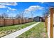 This backyard showcases a well-manicured lawn, a privacy fence, and a walkway to the garage at 1656 Roosevelt Ave, Indianapolis, IN 46218