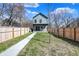 A spacious backyard with a well-maintained lawn, a fenced perimeter, and a concrete walkway at 1656 Roosevelt Ave, Indianapolis, IN 46218