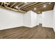 Finished basement with exposed beams, white brick, and wood flooring at 1656 Roosevelt Ave, Indianapolis, IN 46218