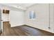 Finished basement room with white brick and wood flooring at 1656 Roosevelt Ave, Indianapolis, IN 46218