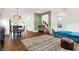 Open concept living area with teal sofa, dining area, and hardwood floors at 1656 Roosevelt Ave, Indianapolis, IN 46218