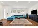 Spacious living room with teal sectional sofa, wood floors, and large TV at 1656 Roosevelt Ave, Indianapolis, IN 46218