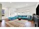 Modern living room featuring teal sectional sofa, wood floors, and stylish decor at 1656 Roosevelt Ave, Indianapolis, IN 46218