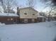 Back of house with brick and siding, snowy yard at 1726 Mccollough Dr, Indianapolis, IN 46260